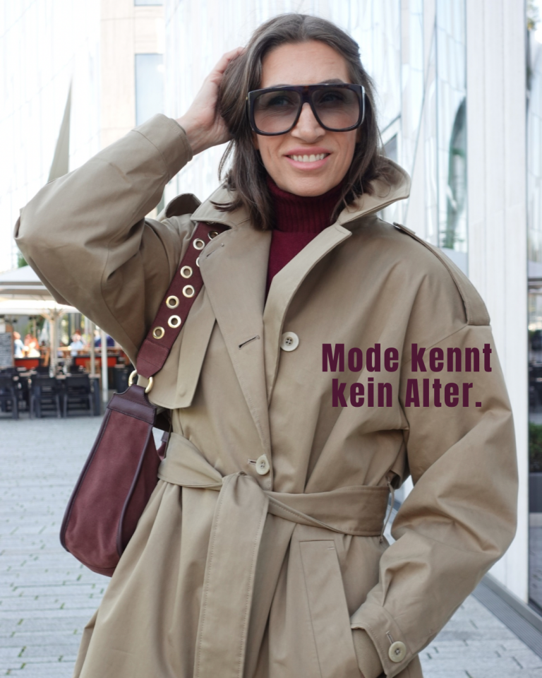 Streetstyle über 50: Trenchcoat in Dark Sand, kombiniert mit Bordeaux Boots und Tasche.