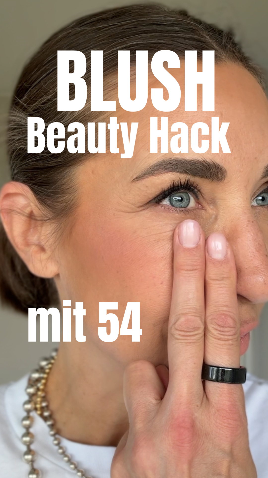 rau 50+ trägt Blush auf die Wangen auf und zeigt den Lifting-Effekt für ein frisches, strahlendes Aussehen